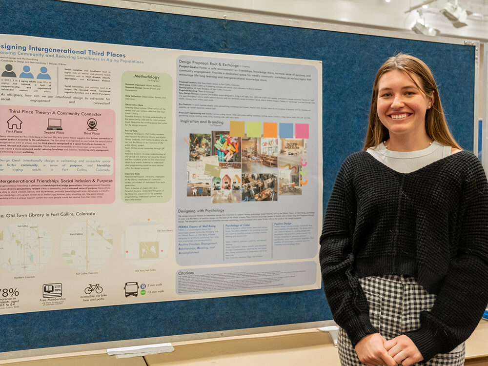 delaney obrien poses by research poster