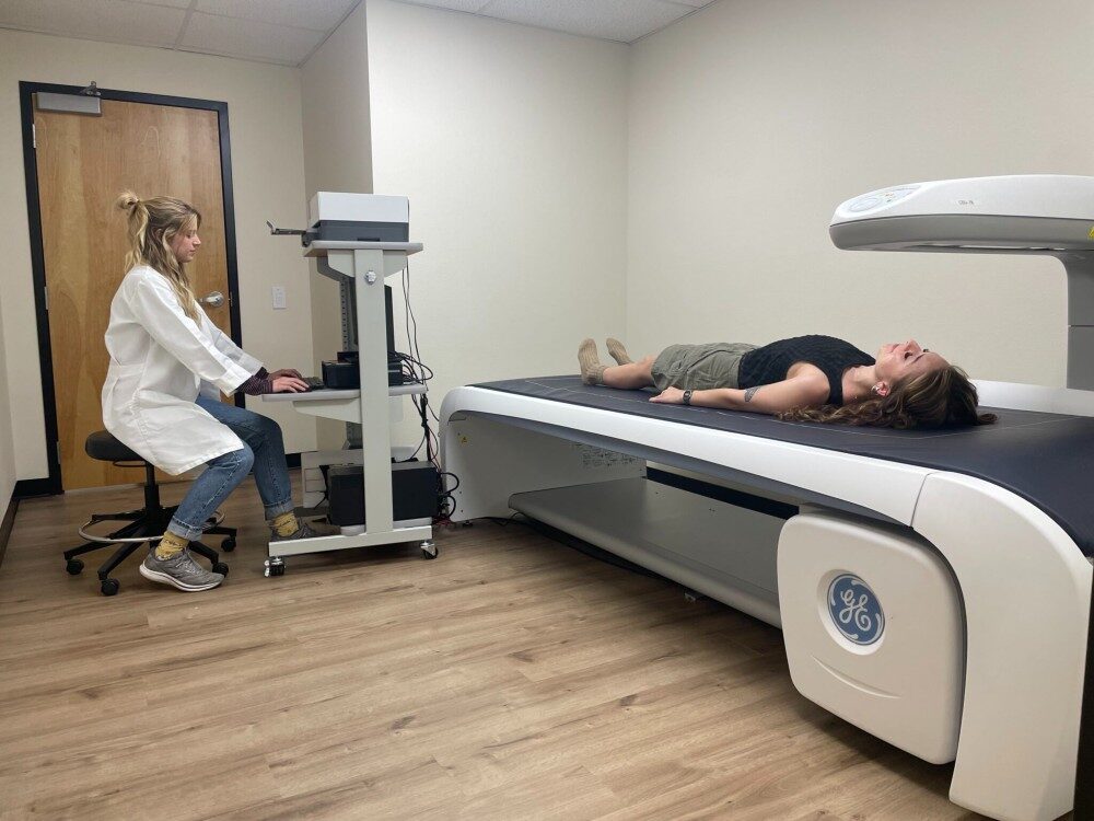 A clinician uses a DXA body composition scanner to assess a research subject