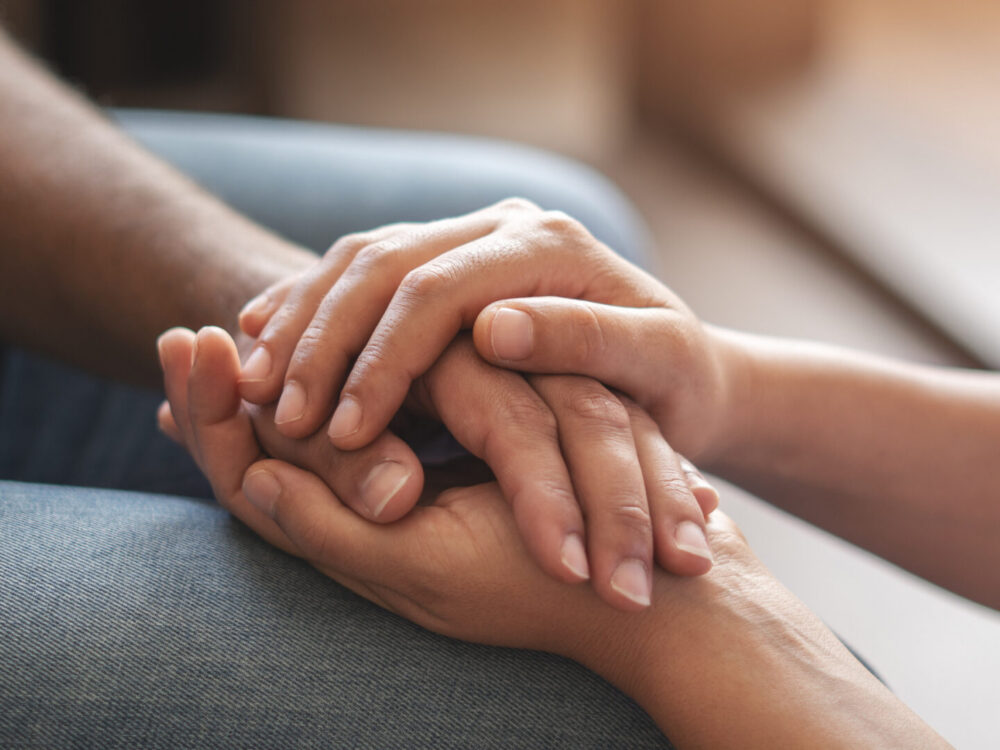 Closeup shot of two unrecognizable people holding hands in comfort